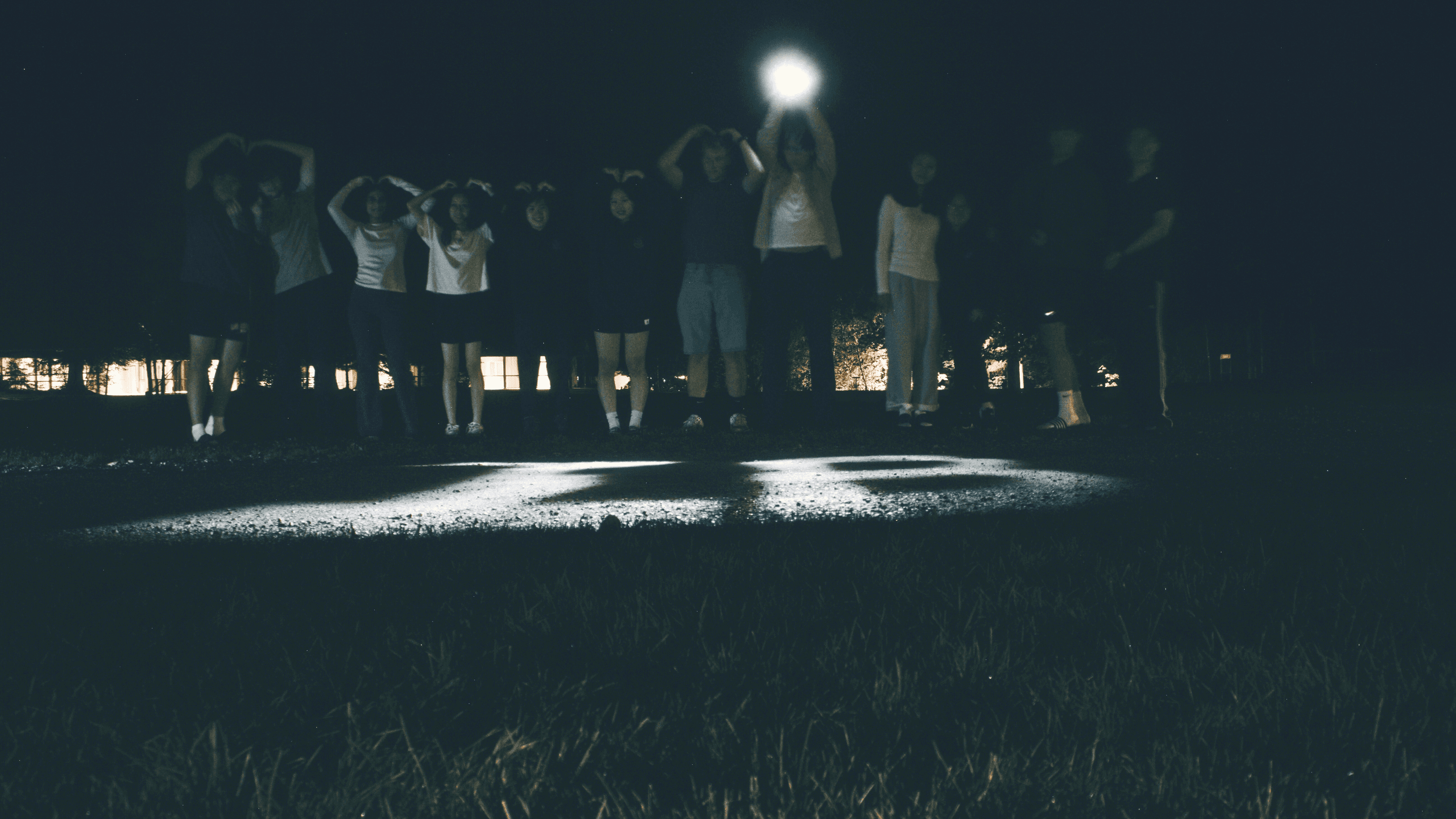A group gathered outdoors at night during an IB Director camp